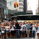 Pedestrians gather to watch as officers from the NYPD monitor a man as he climbs the outside of Trump Tower in New York